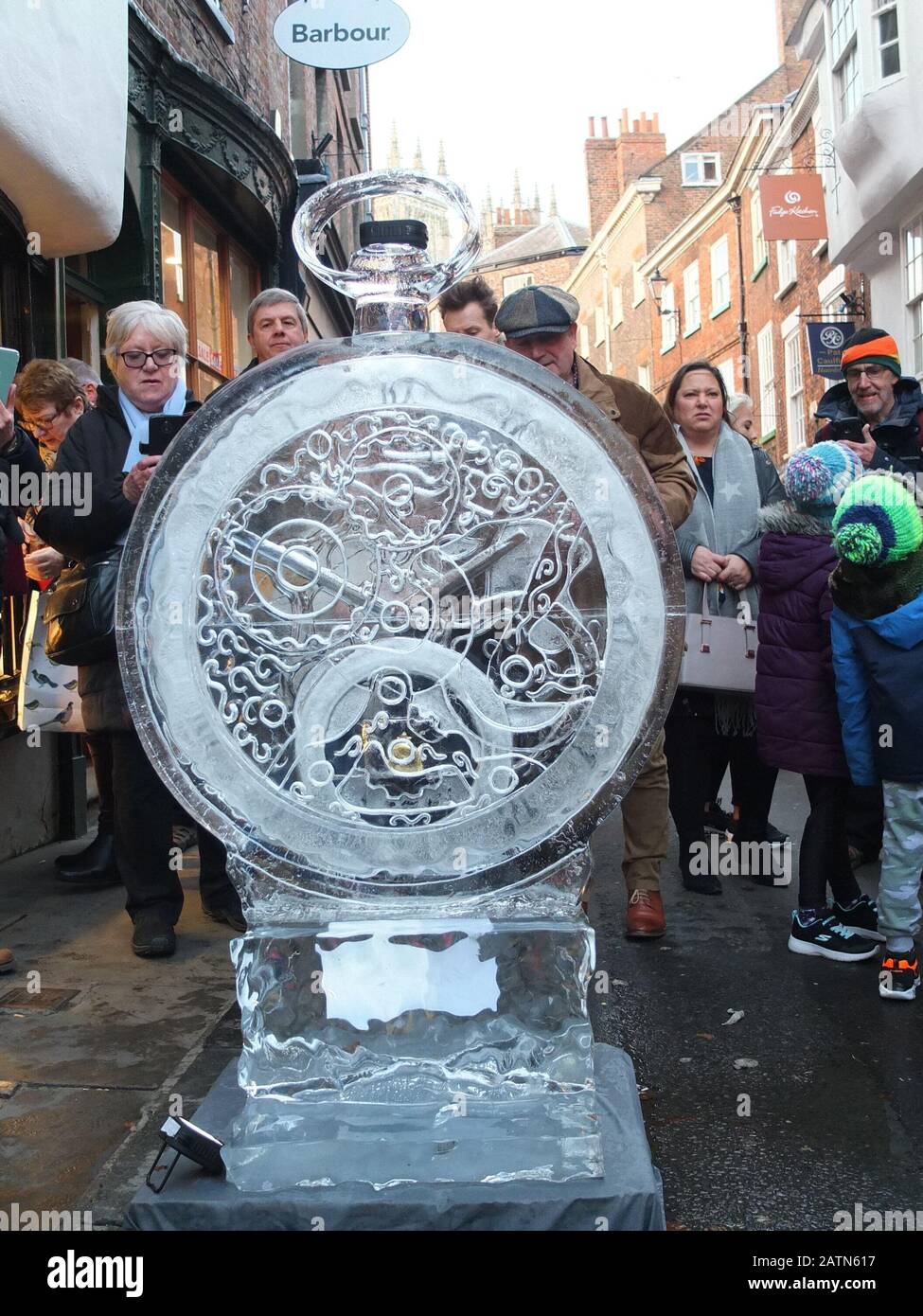 Les foules qui regardèrent une sculpture de glace complexe sous la forme d'une montre de poche à l'extérieur des joyaux de Bradley sur le petit pétergate à la piste de glace York 2020 Banque D'Images