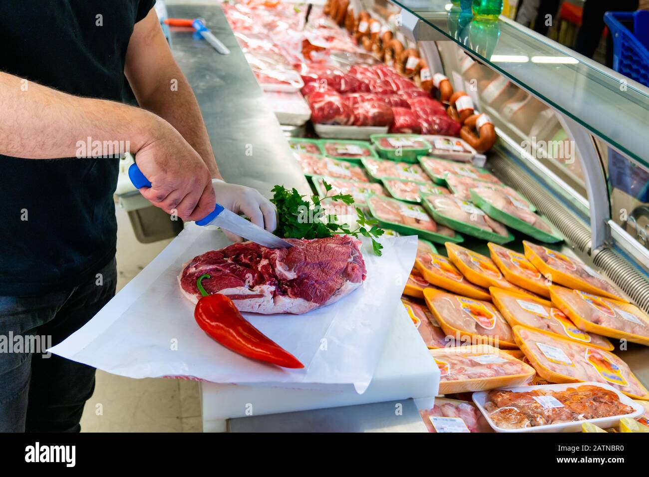 Le boucher travaille dans une section de viande d'un marché et hacher de la viande. Concept alimentaire et culinaire Banque D'Images