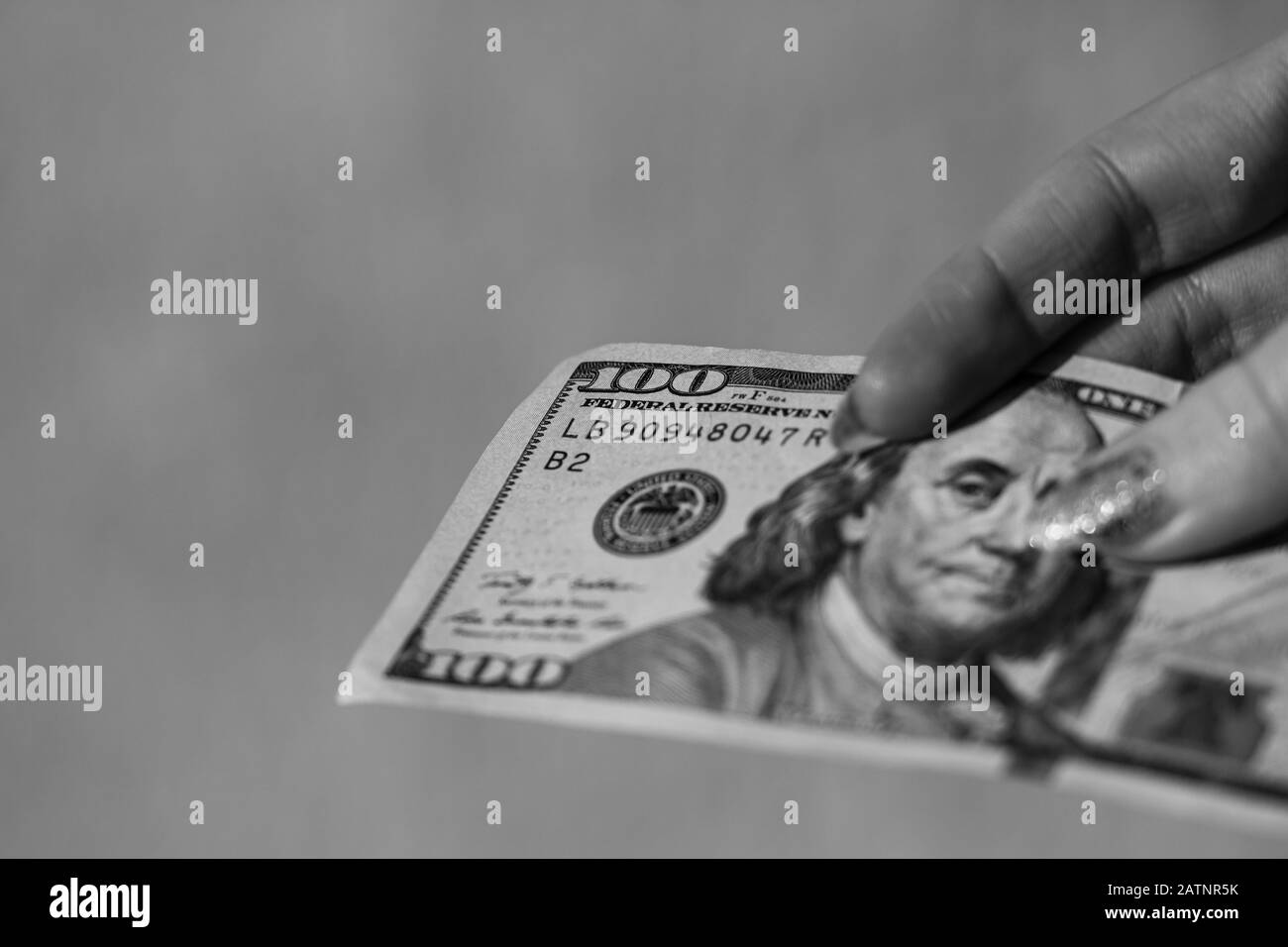 Mains donnant de l'argent comme un pot-de-vin ou des conseils. Détenir des billets de banque en dollars américains sur un fond flou, la monnaie américaine Banque D'Images