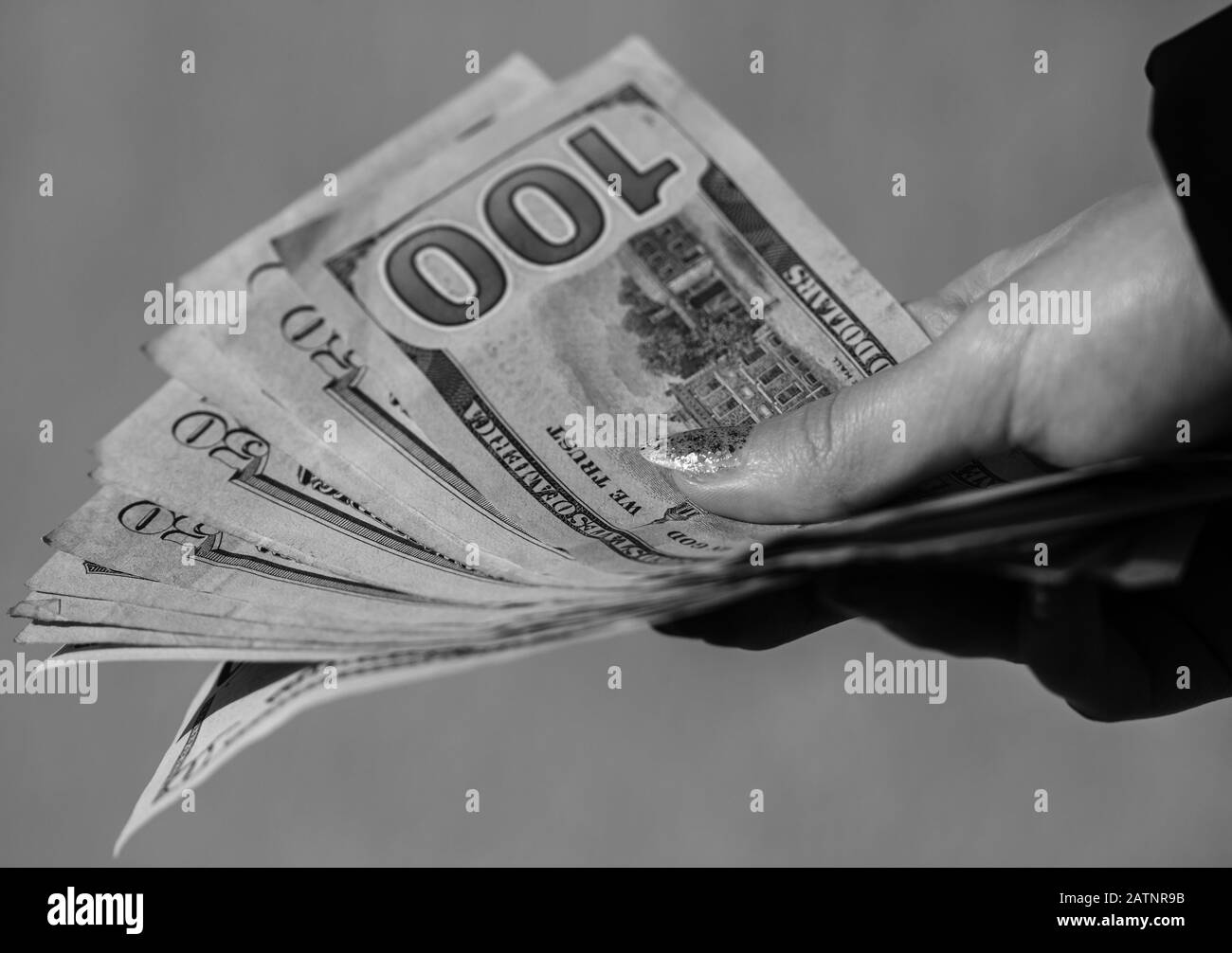 Mains donnant de l'argent comme un pot-de-vin ou des conseils. Détenir des billets de banque en dollars américains sur un fond flou, la monnaie américaine Banque D'Images