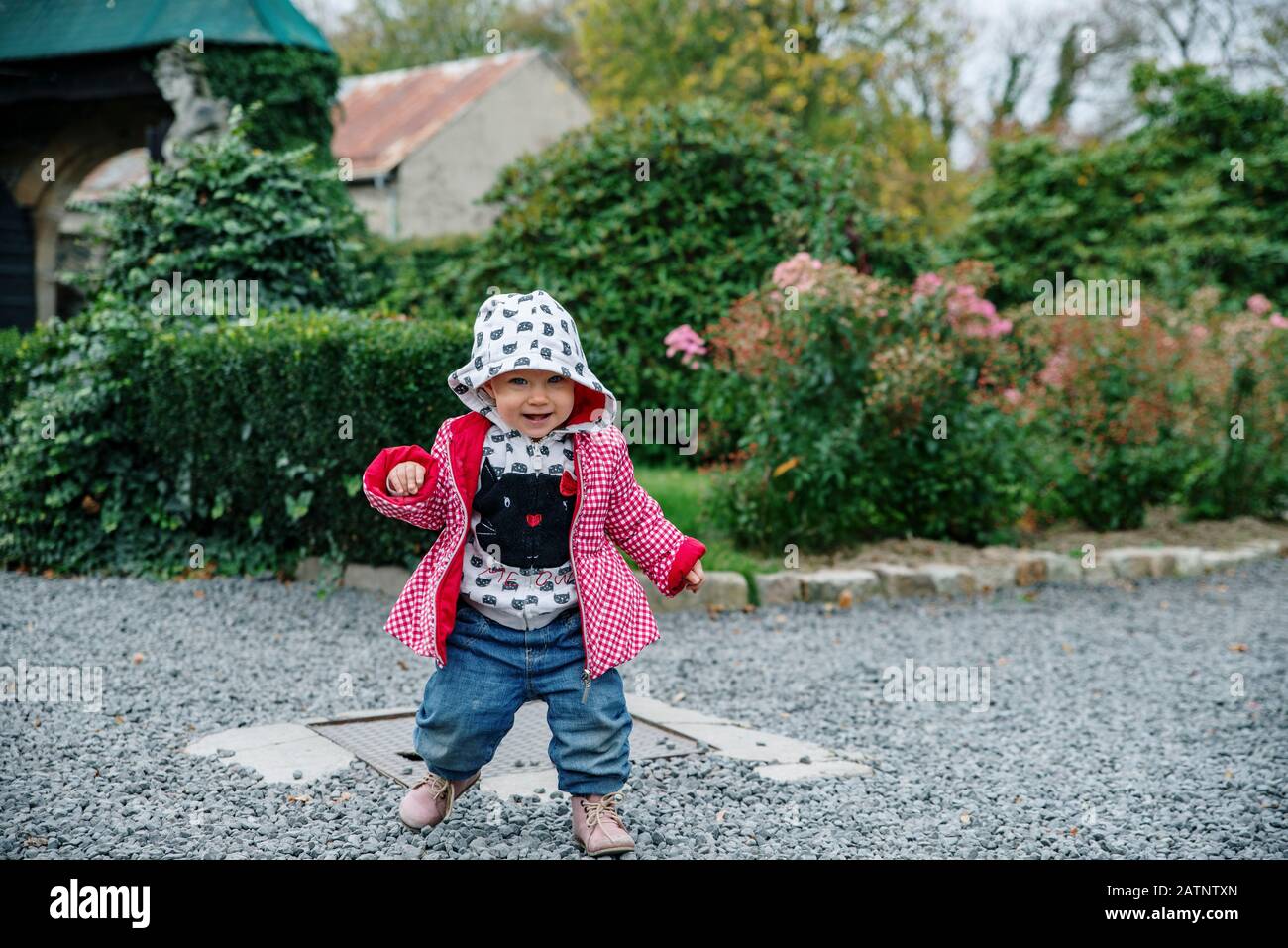 Petite fille marchant dans le jardin, automne Banque D'Images