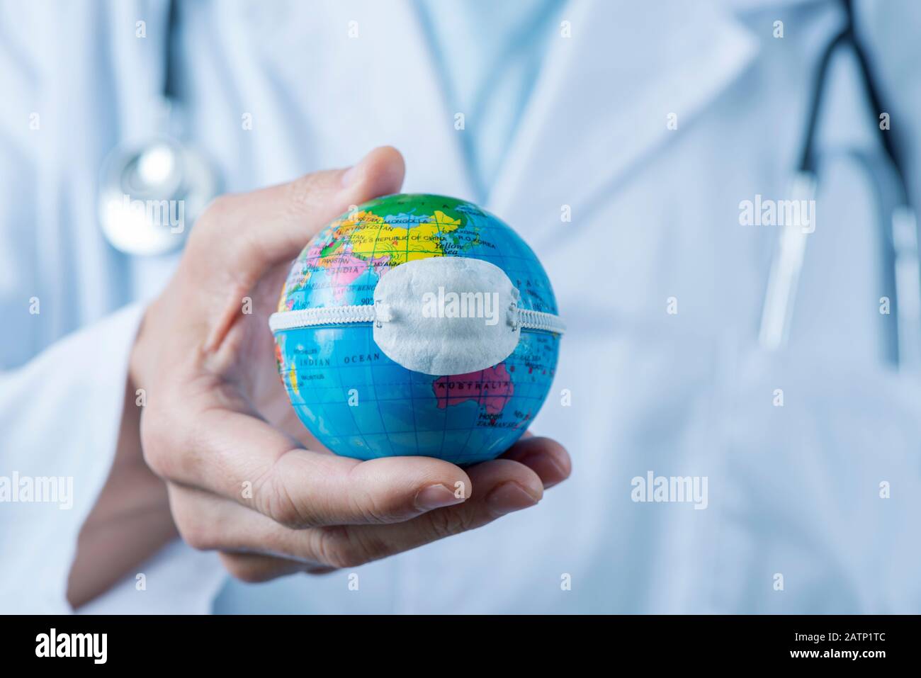 Gros plan d'un médecin caucasien tenant un globe mondial avec un masque de protection placé sur la Chine, représentant la récente épidémie de coronavirus ou le pro Banque D'Images