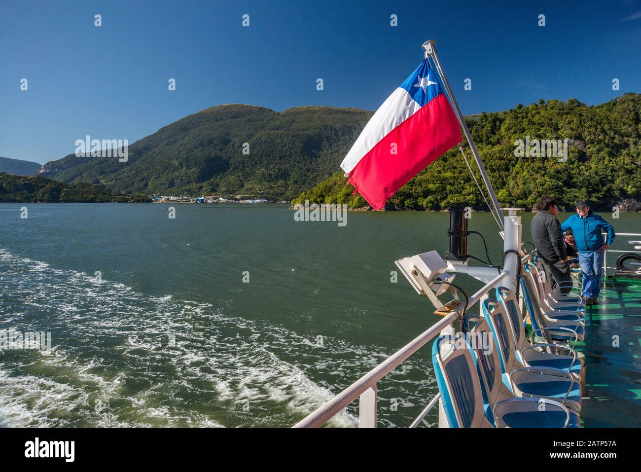 Le ferry de Quelat quitte son sillage dans le fjord d'Aisen, Puerto Chacabuco à distance, région d'Aysen, Patagonia, Chili Banque D'Images
