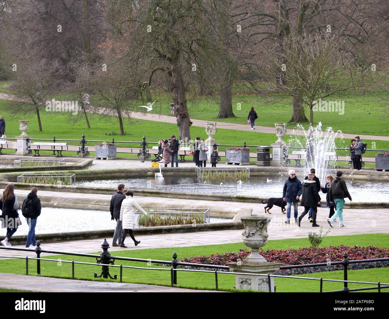 Les gens qui se promenent dans les jardins italiens au soleil d'hiver à Kensington Gardens London, Royaume-Uni. Banque D'Images