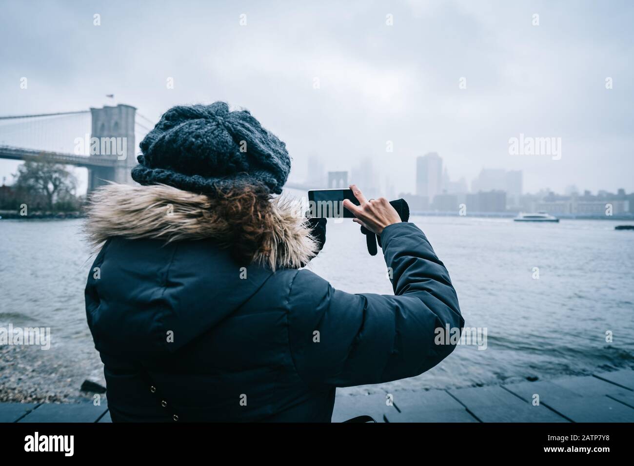 Femme de tourisme avec vêtements chauds prenant une photo de New York Skyline Banque D'Images