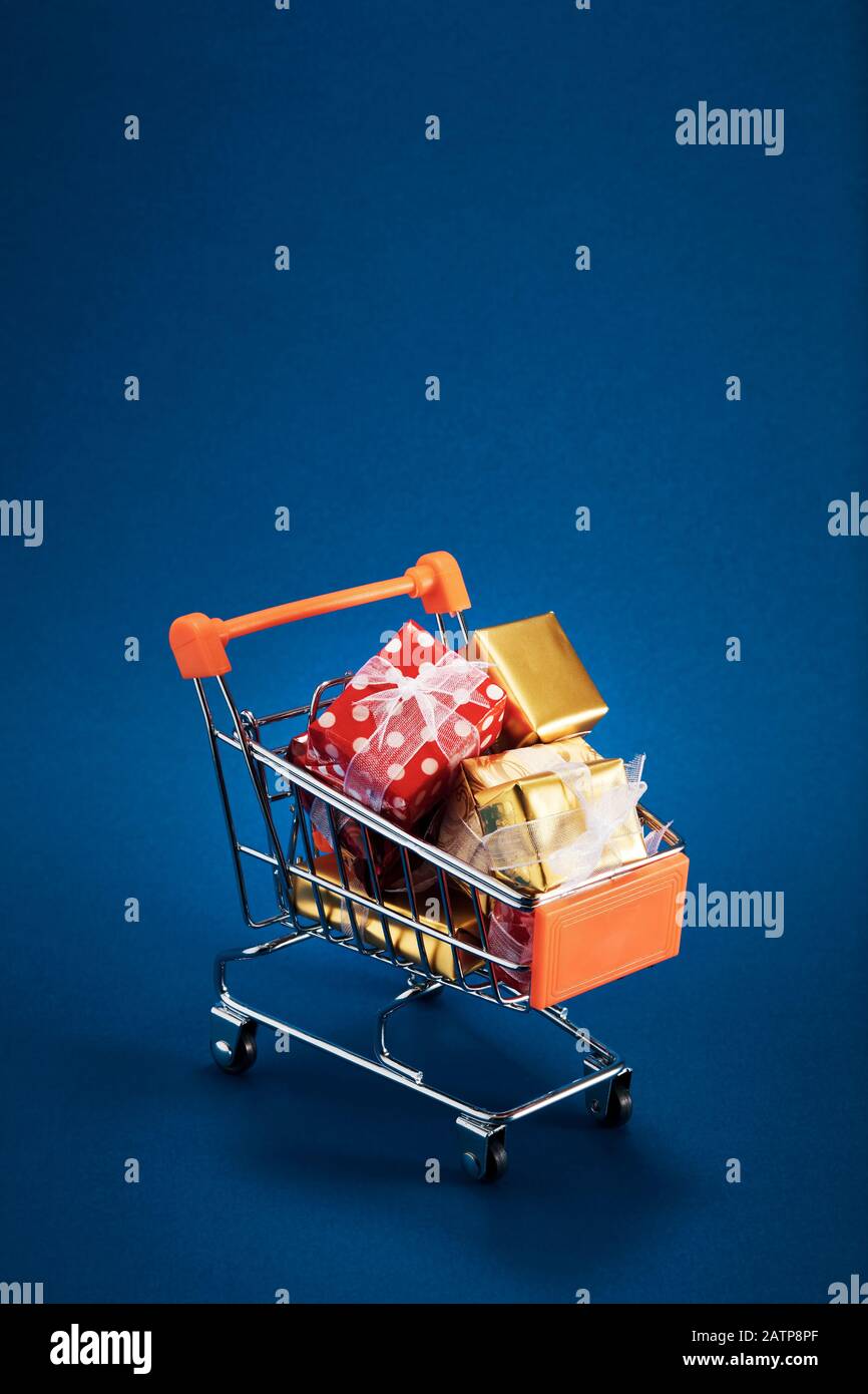 Panier rempli de cadeaux de Noël sur fond bleu. Banque D'Images