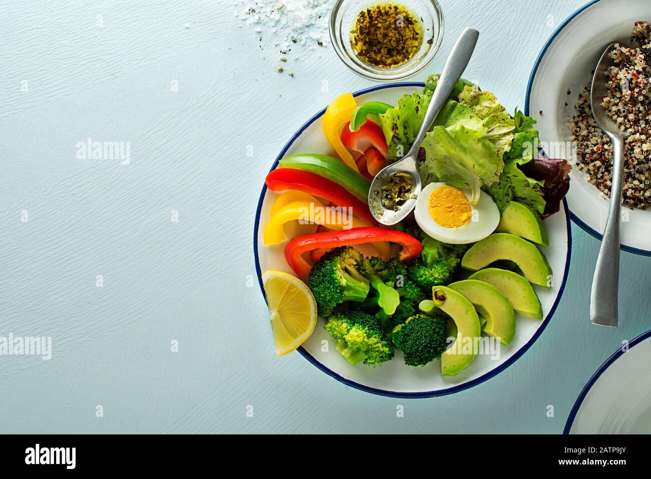Repas de salade sain avec quinoa, oeuf et légumes frais mélangés sur fond bleu vue de dessus. Alimentation et santé. Concept de repas sain Banque D'Images