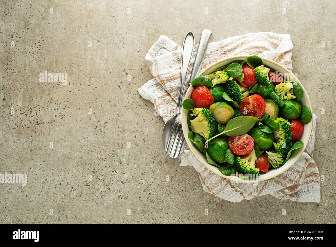 Salade verte saine avec légumes frais cuits sur fond gris Banque D'Images