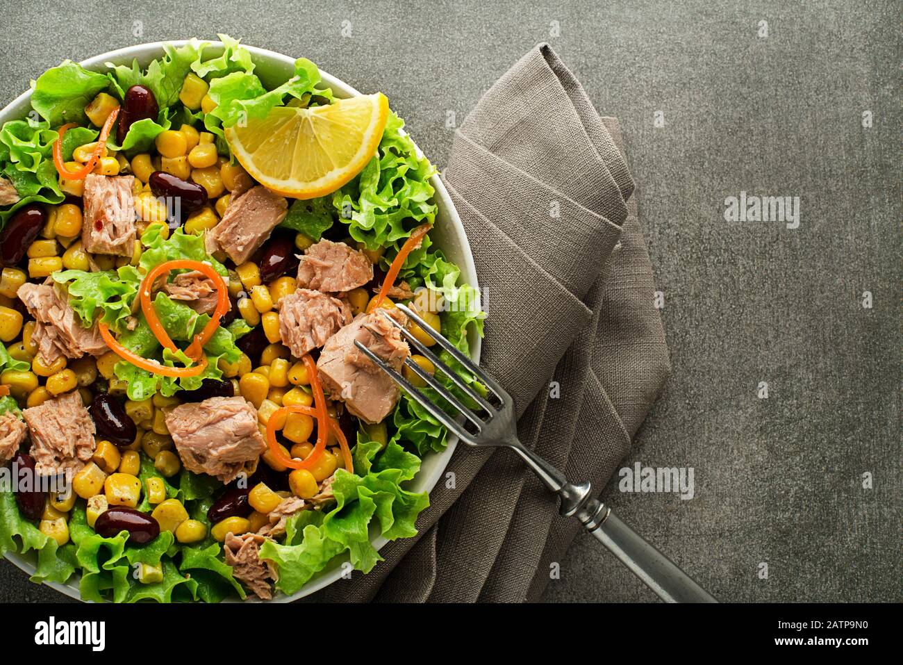 Salade verte saine avec thon, maïs et haricots sur fond gris. Salade mexicaine de maïs. Banque D'Images