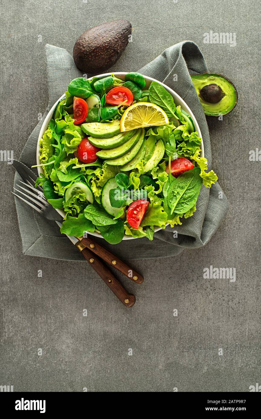 Salade verte saine avec avocat sur fond de table gris Banque D'Images