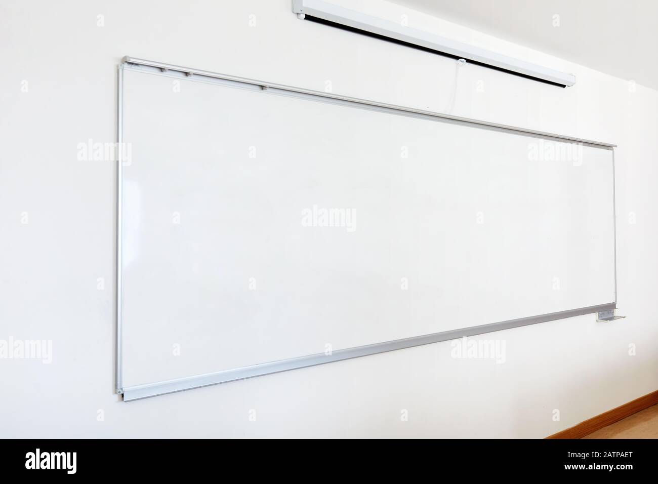 Tableau blanc et écran de projection pliable sur le mur de la salle de classe. Gros plan avec espace de copie. Banque D'Images