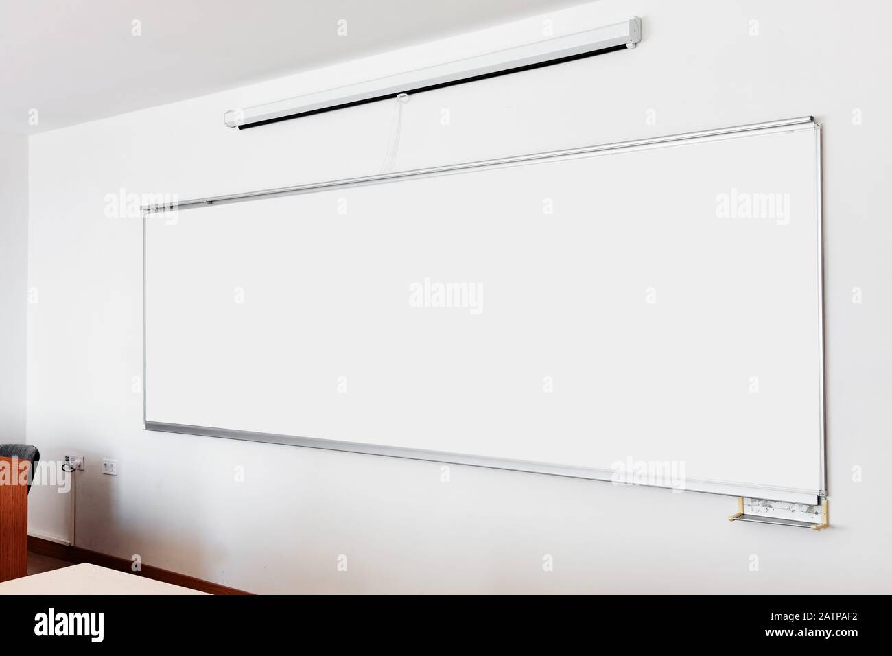 Tableau blanc et écran de projection pliable sur le mur de la salle de classe. Gros plan avec espace de copie. Banque D'Images
