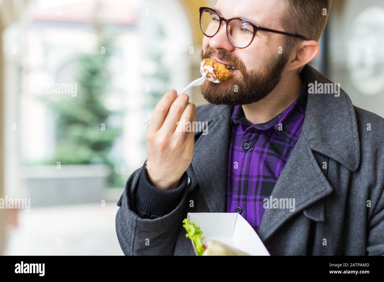 L'homme tient une assiette unique avec de délicieux plats juifs traditionnels en falafel à base de pois chiches au festival de la nourriture de la rue. Banque D'Images