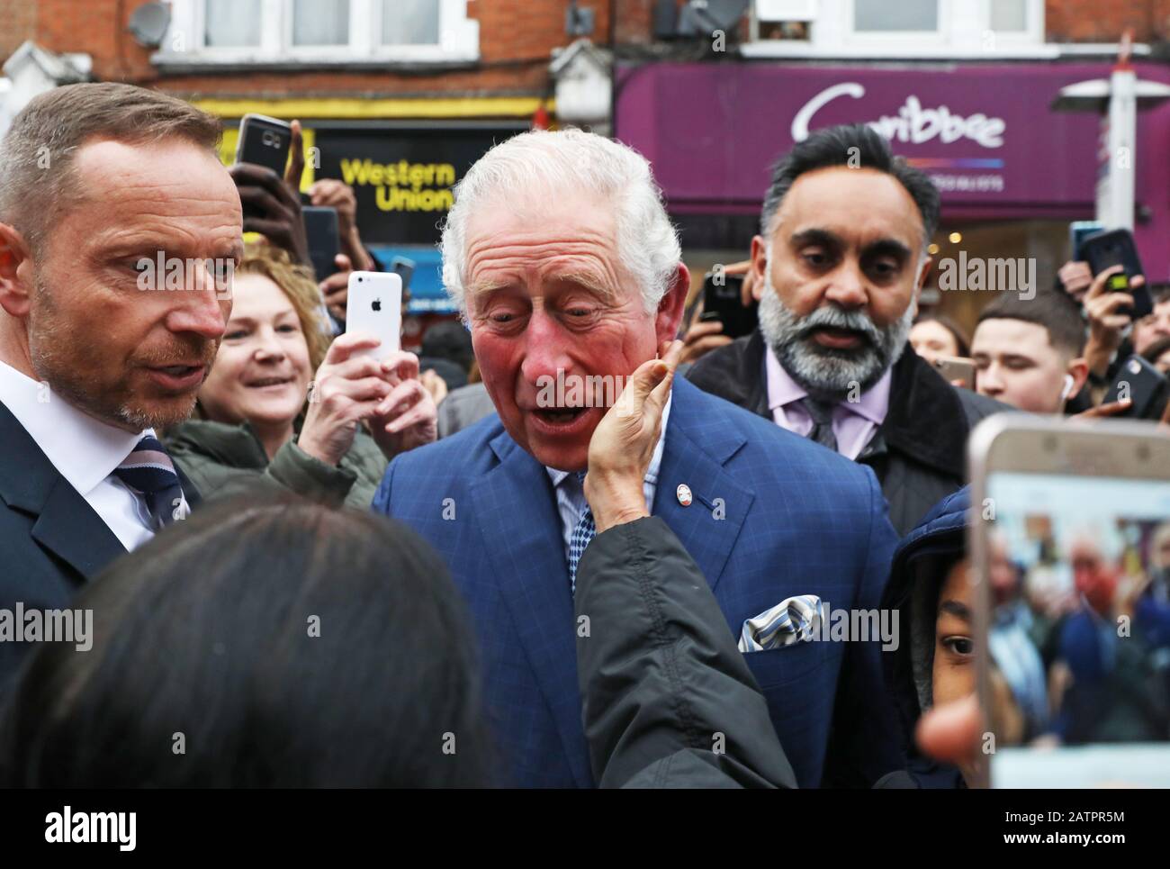 Le Prince de Galles est accueilli par des membres du public alors qu'il quitte un magasin TK Maxx à Tooting High Street, Londres, après avoir rencontré des employés qui sont des anciens de Prince's Trust au magasin. Banque D'Images