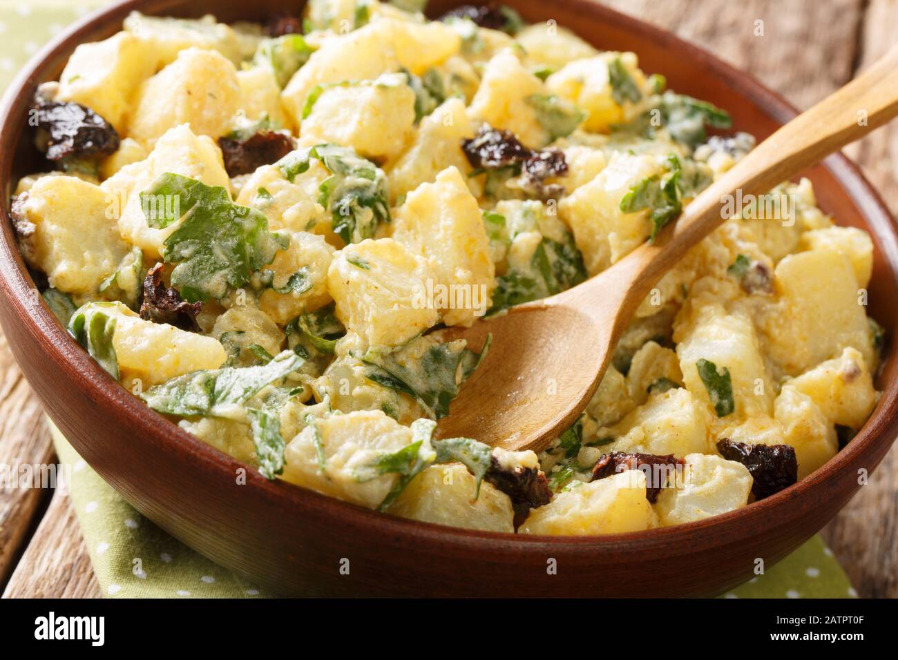 Maroc cuisine salade de pommes de terre avec yaourt, herbes, épices et olives séchées près dans un bol sur la table. Horizontal Banque D'Images
