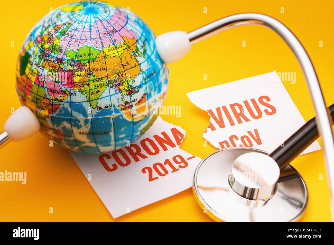 Stéthoscope, globe et feuille de papier déchirée avec l'inscription sur un fond jaune. Concept de victoire du coronavirus 2019-nCoV Banque D'Images
