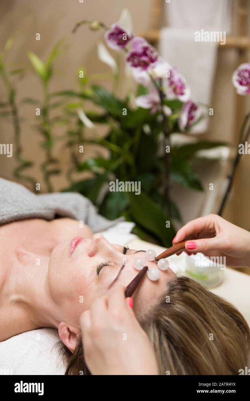 Femme ayant un traitement de masseuse à rouleaux de visage professionnel dans le salon Banque D'Images Femme ayant un traitement de masseuse à rouleaux de visage professionnel dans le salon Banque D'Images