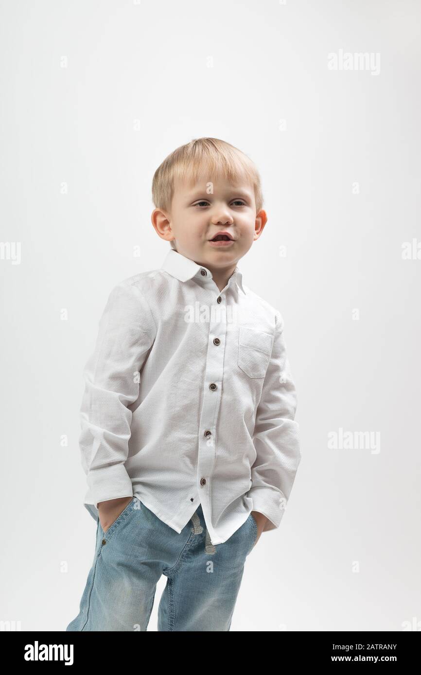 Portrait d'un garçon charismatique élégant et tendance dans une chemise blanche sur fond clair raconte quelque chose. Concept pour les articles sur le peop d'affaires Banque D'Images
