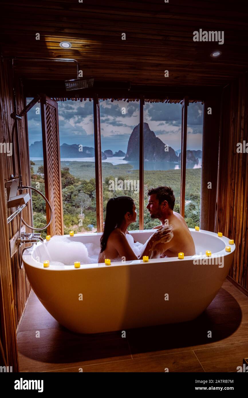 Couple en vacances lune de miel, baignoire avec vue sur la baie de la baie  de Phangnga, salle de bains en bois de luxe pendant le coucher du soleil  Thaïlande Asie Photo
