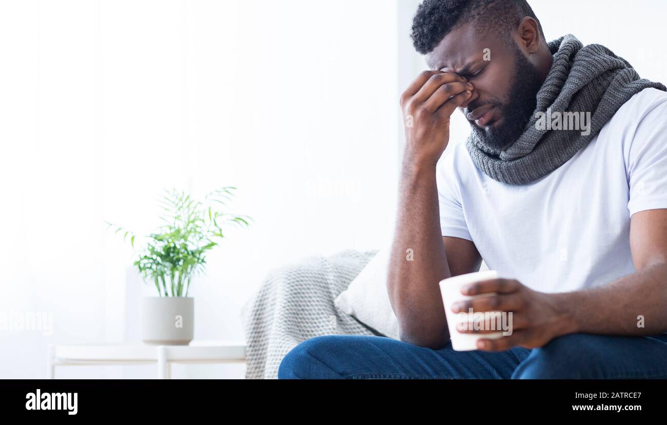 Homme noir avec réchauffement de la grippe avec tasse avec thé chaud à la maison Banque D'Images
