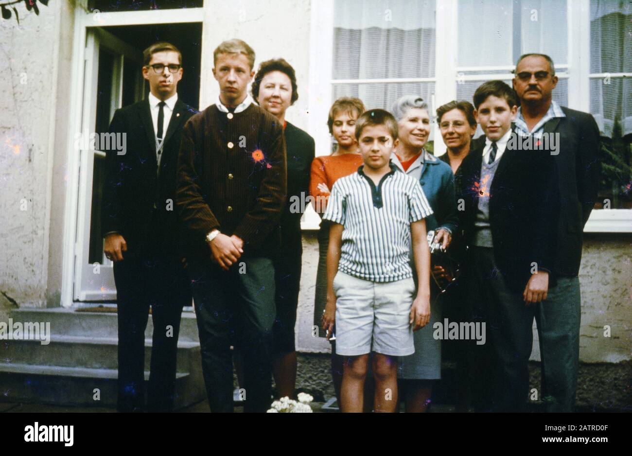 Photographie vernaculaire prise sur une transparence de film analogique de 35 mm, considérée comme représentant un groupe de personnes debout sur un sol gris à l'extérieur d'un bâtiment, 1970. Les principaux sujets/objets détectés incluent Les Personnes et les hommes. () Banque D'Images