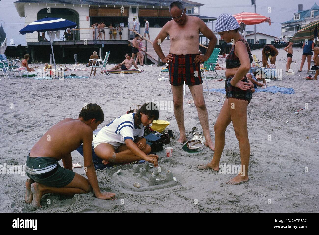 Photographie vernaculaire prise sur une transparence de film analogique de 35 mm, considérée comme représentant des personnes sur la plage pendant la journée, 1970. Les principaux sujets/objets détectés sont Plage et Groupe. () Banque D'Images