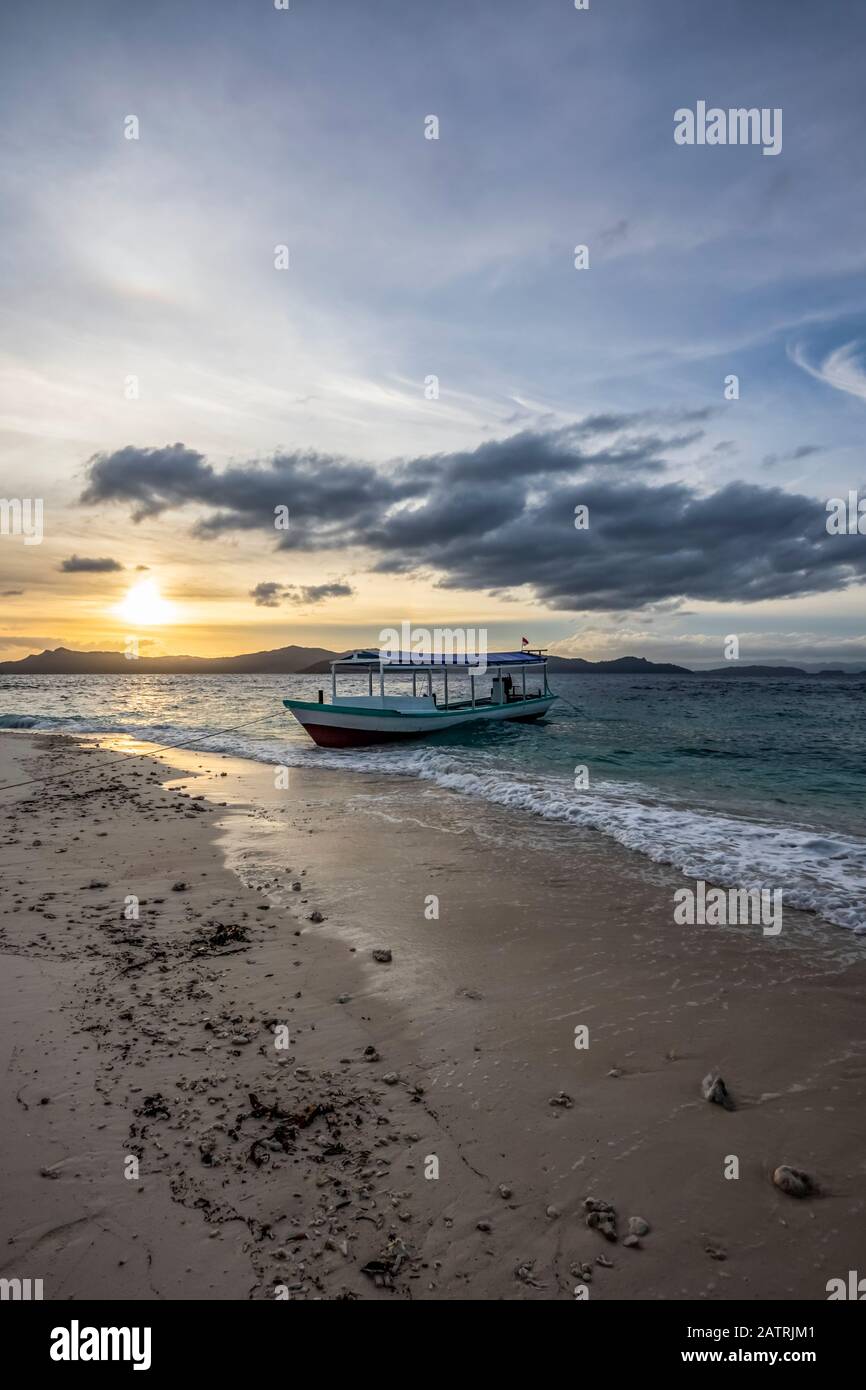 Bateau sur la plage au coucher du soleil, Pulau Kelelawar (île de Bat) ; Papouasie occidentale, Indonésie Banque D'Images