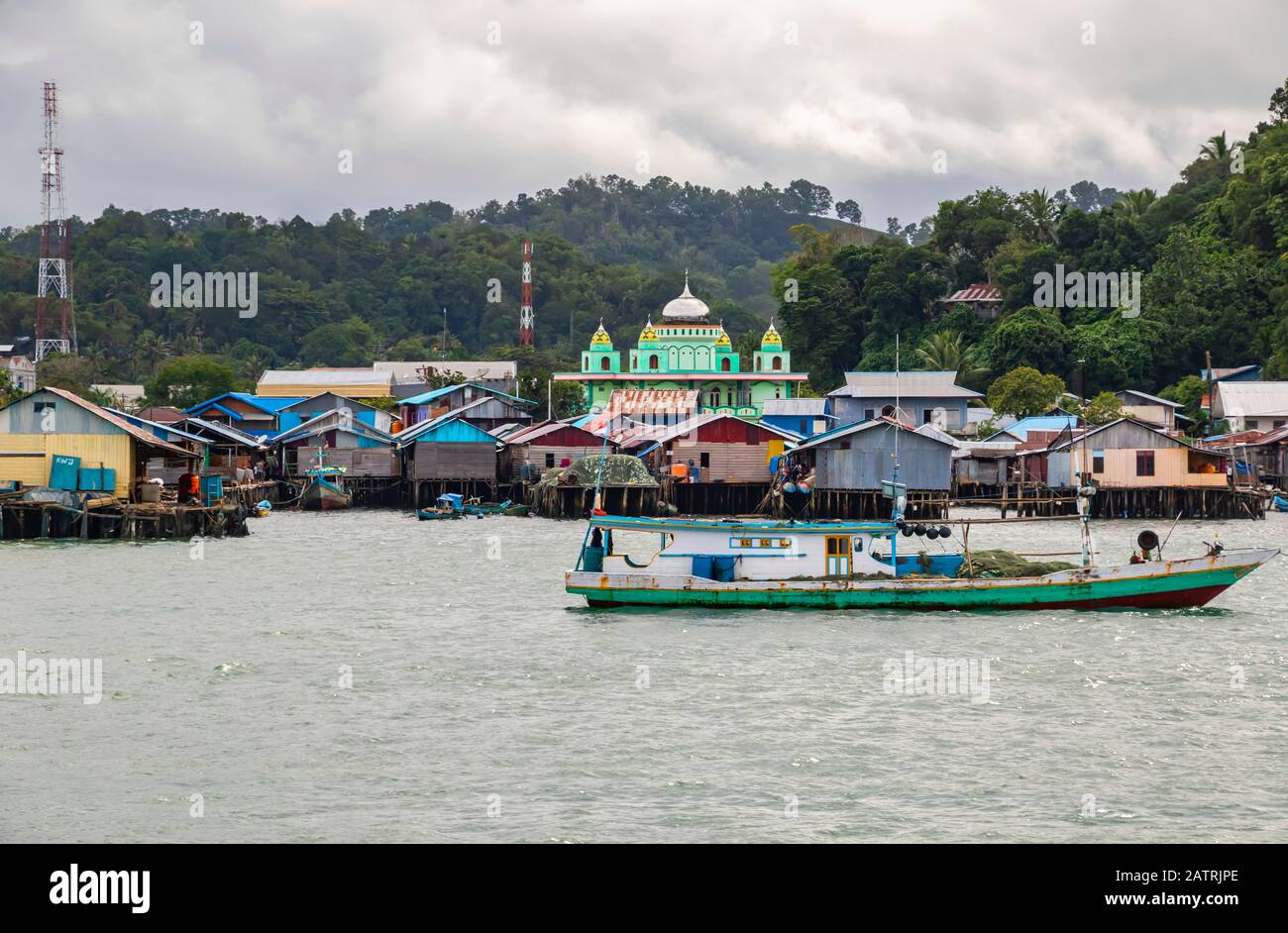 Port de Sorong avec des bâtiments colorés et un bateau ; Sorong, Papouasie occidentale, Indonésie Banque D'Images