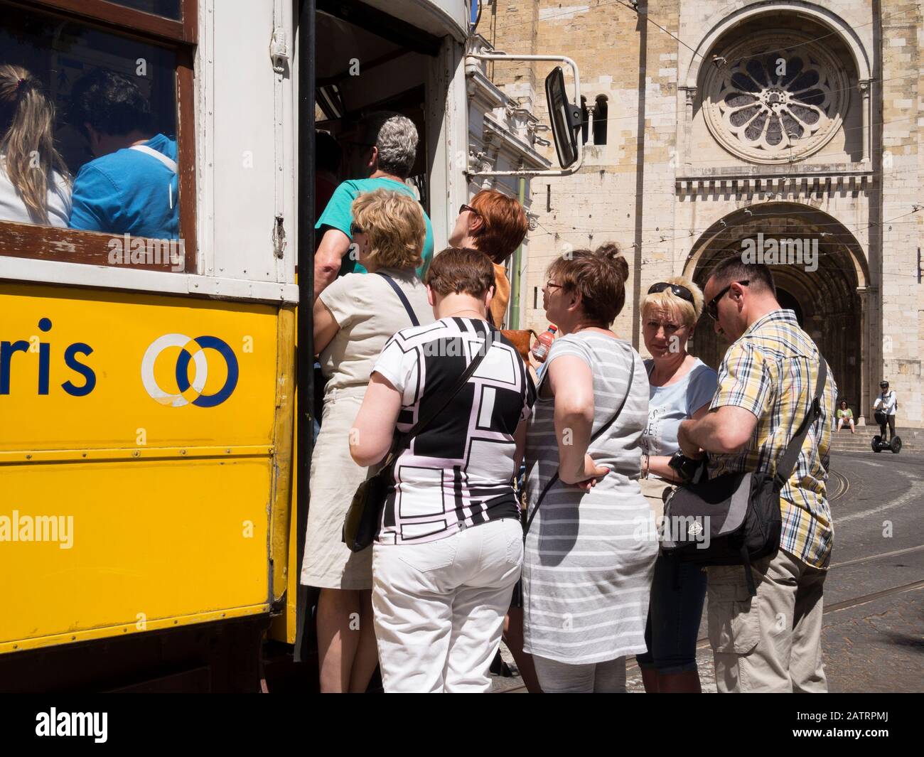 Les touristes prenant le tram 28 devant la cathédrale de Lisbonne à Alfama, Lisbonne. Le tramway numéro 28 de Lisbonne traverse les quartiers touristiques populaires Banque D'Images