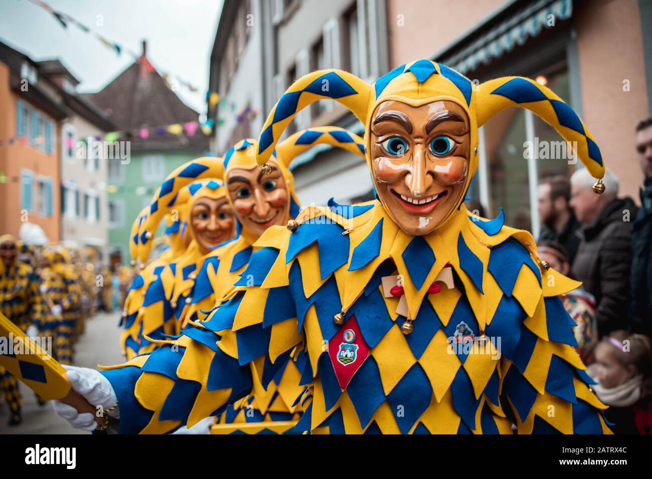 Bajass de Waldkirch - des personnages joyaux en robe jaune et bleue mars dans un grand groupe pendant le défilé de carnaval à Staufen, dans le sud de l'Allemagne Banque D'Images