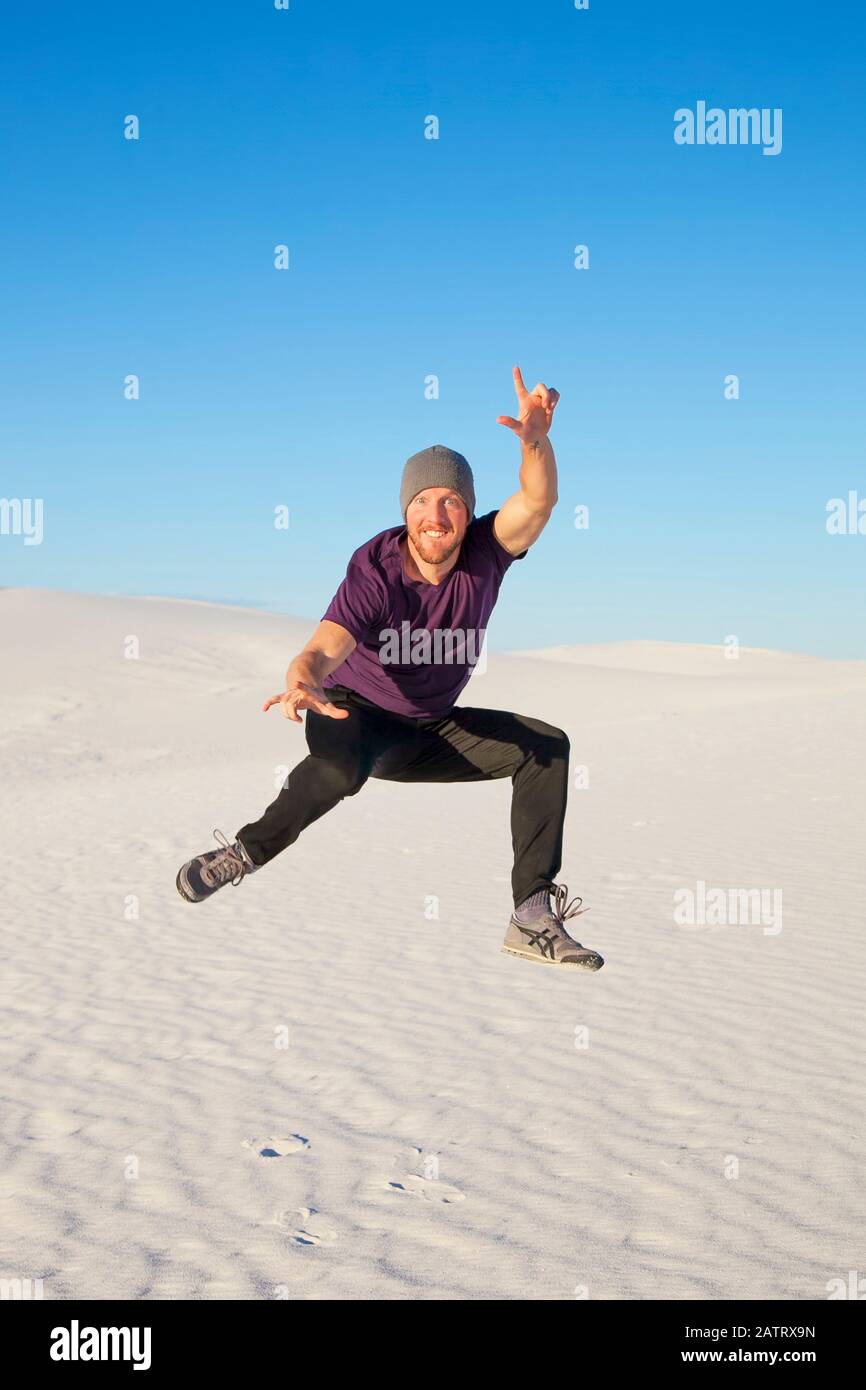 Homme insouciant en plein air sur le sable blanc au ciel bleu, White Sands National Monument; Alamogordo, Nouveau-Mexique, États-Unis d'Amérique Banque D'Images