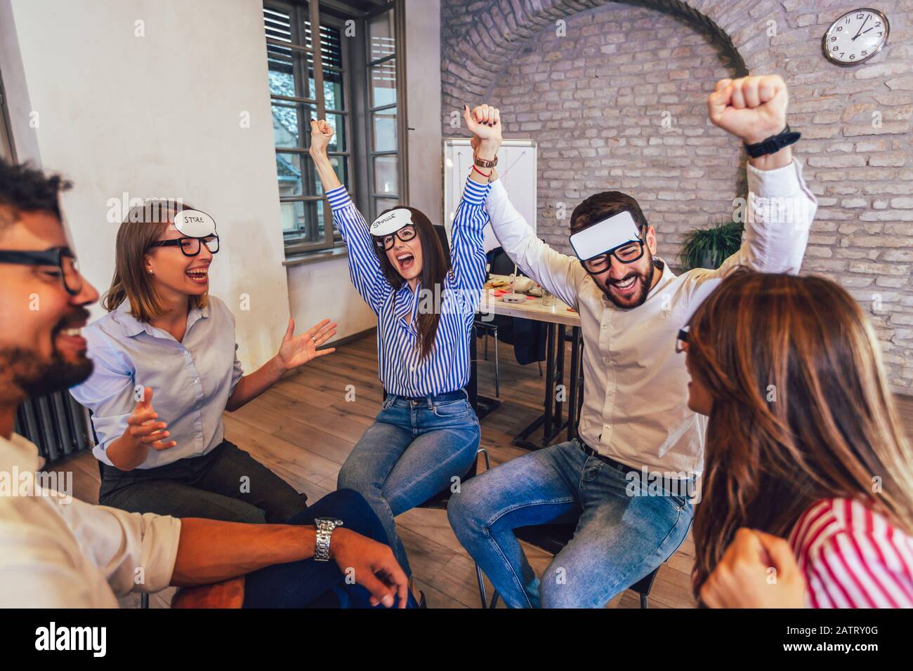 Heureux sympathique équipe d'affaires ayant plaisir à la formation d'entreprise, activité drôle de teambuilding, jeu deviner qui. Banque D'Images