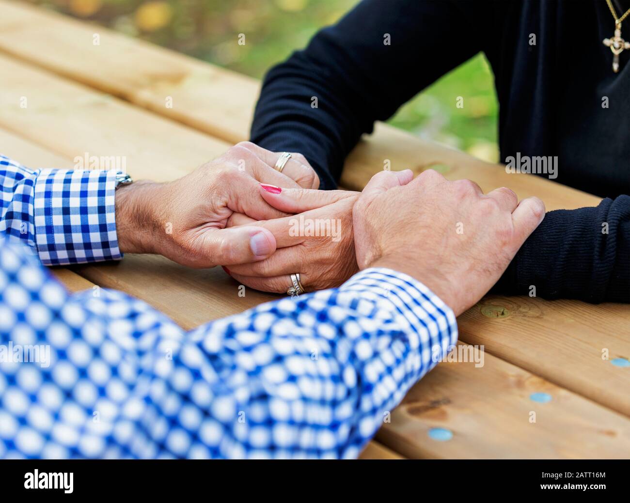 Un couple mature priant ensemble à une table de pique-nique après avoir passé un certain temps de qualité à discuter de leur foi; St. Albert, Alberta, Canada Banque D'Images