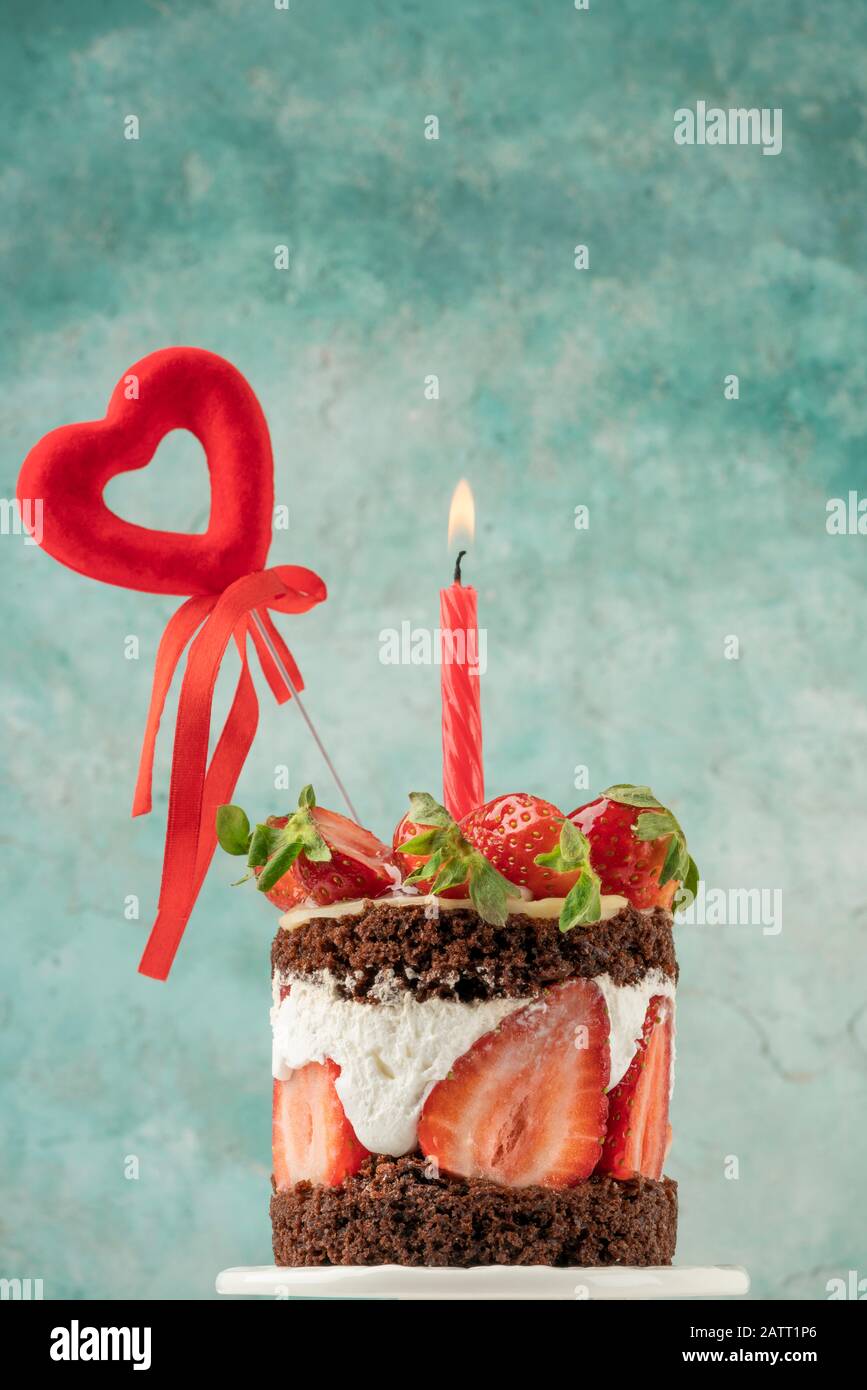 gros plan d'un délicieux gâteau au chocolat et à la fraise décoré de coeur et de bougie Banque D'Images