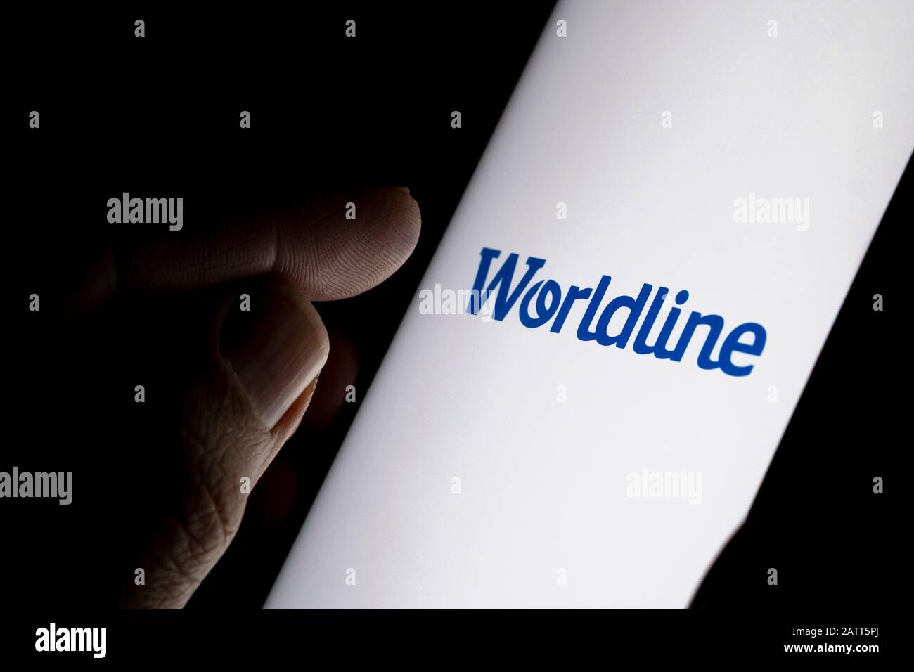 Logo de la société de paiement Worldline sur l'écran bleu et doigt sur le point de le toucher. Photo de concept. Banque D'Images