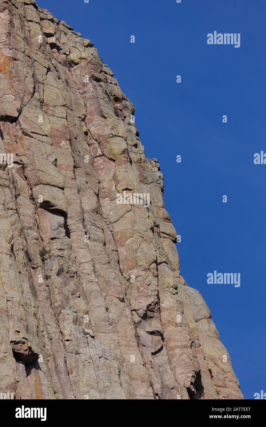 Les spectaculaires colonnes de roche verticales qui forment le monument national de la Tour Devils au Wyoming contre un ciel bleu clair. Banque D'Images