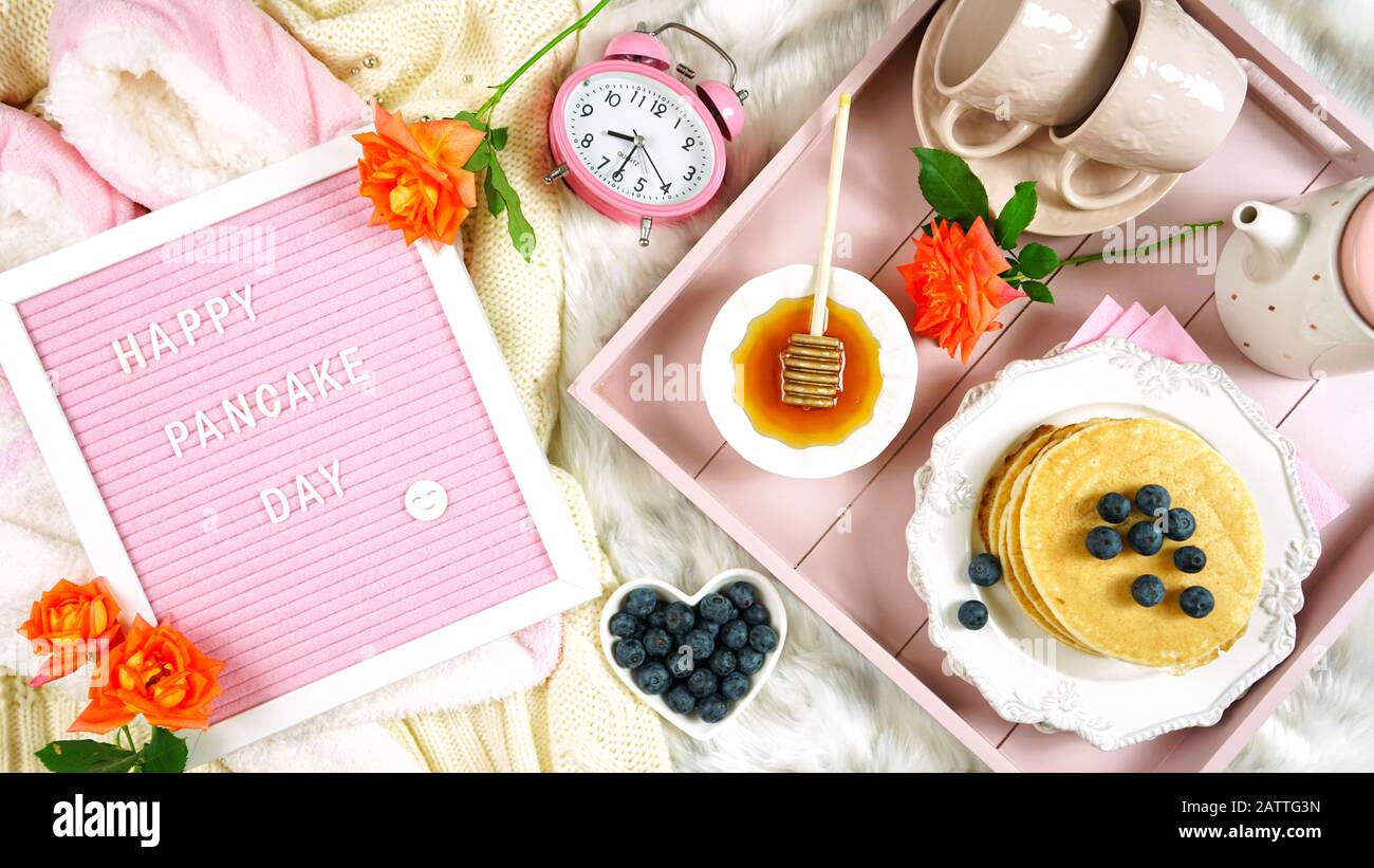 Plateau de petit-déjeuner pancake au lit avec sirop et bleuets fruits mise en page plate vue sur le dessus, avec lettre feutre planche Happy Pancake message de jour. Banque D'Images