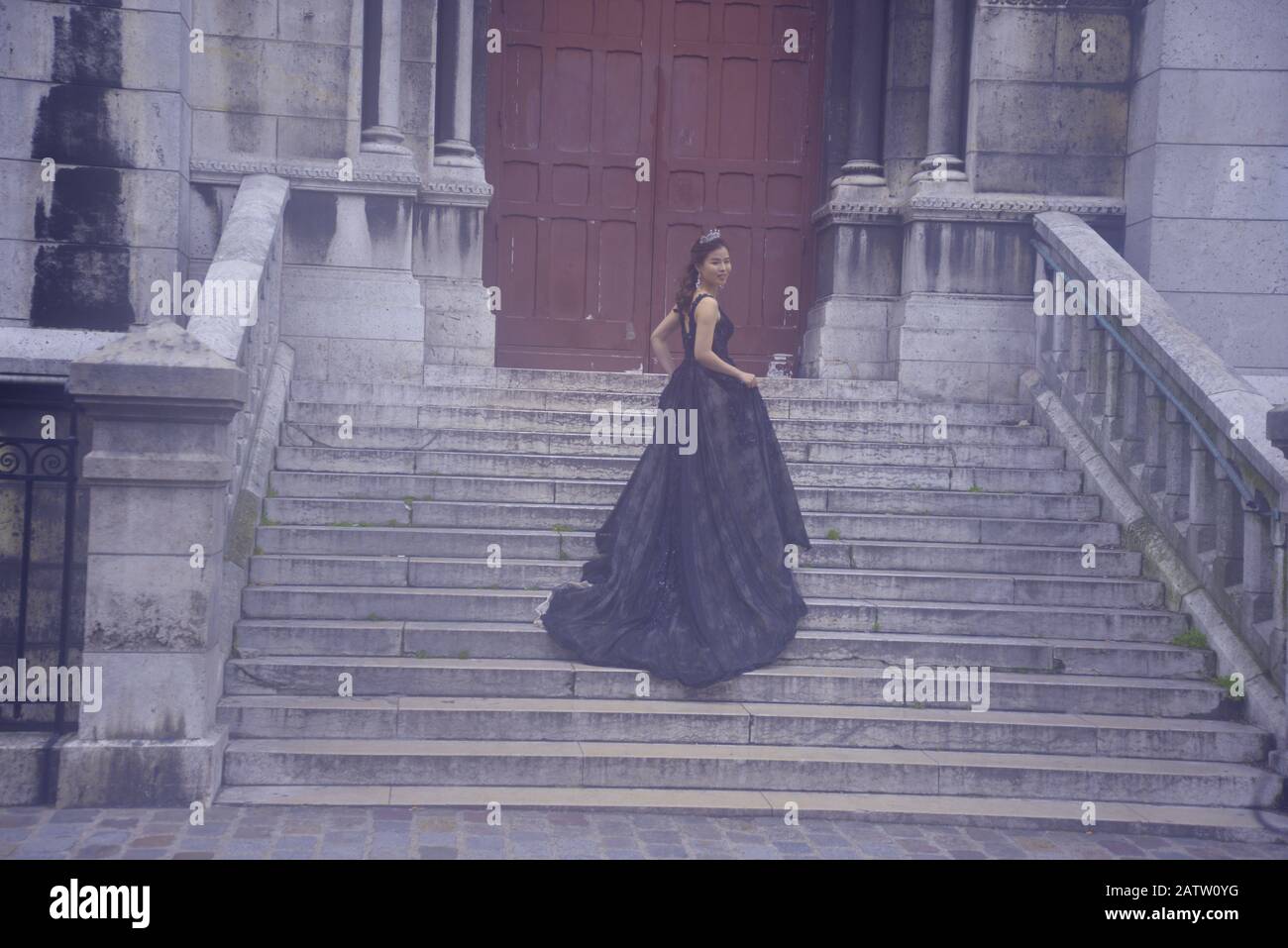 Dame asiatique dans une longue robe noire sur un escalier à Paris, pasakdek Banque D'Images