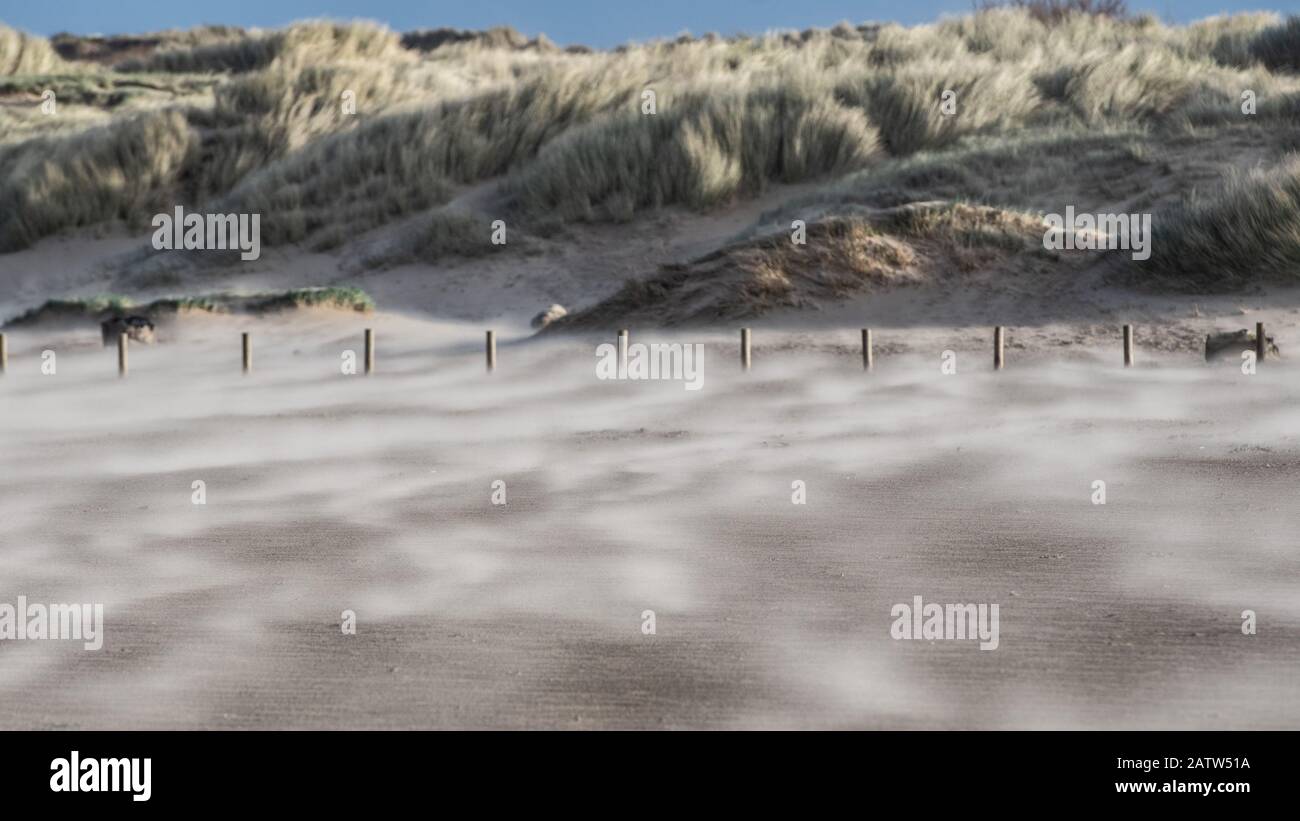 Sable soufflant sur une plage venteuse Banque D'Images