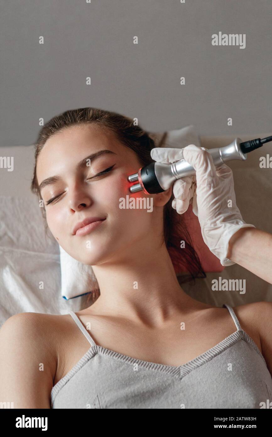 Cosmétologie matérielles. Photo de jeune femme aux yeux clos s'rf procédure de levage dans un salon de beauté Banque D'Images