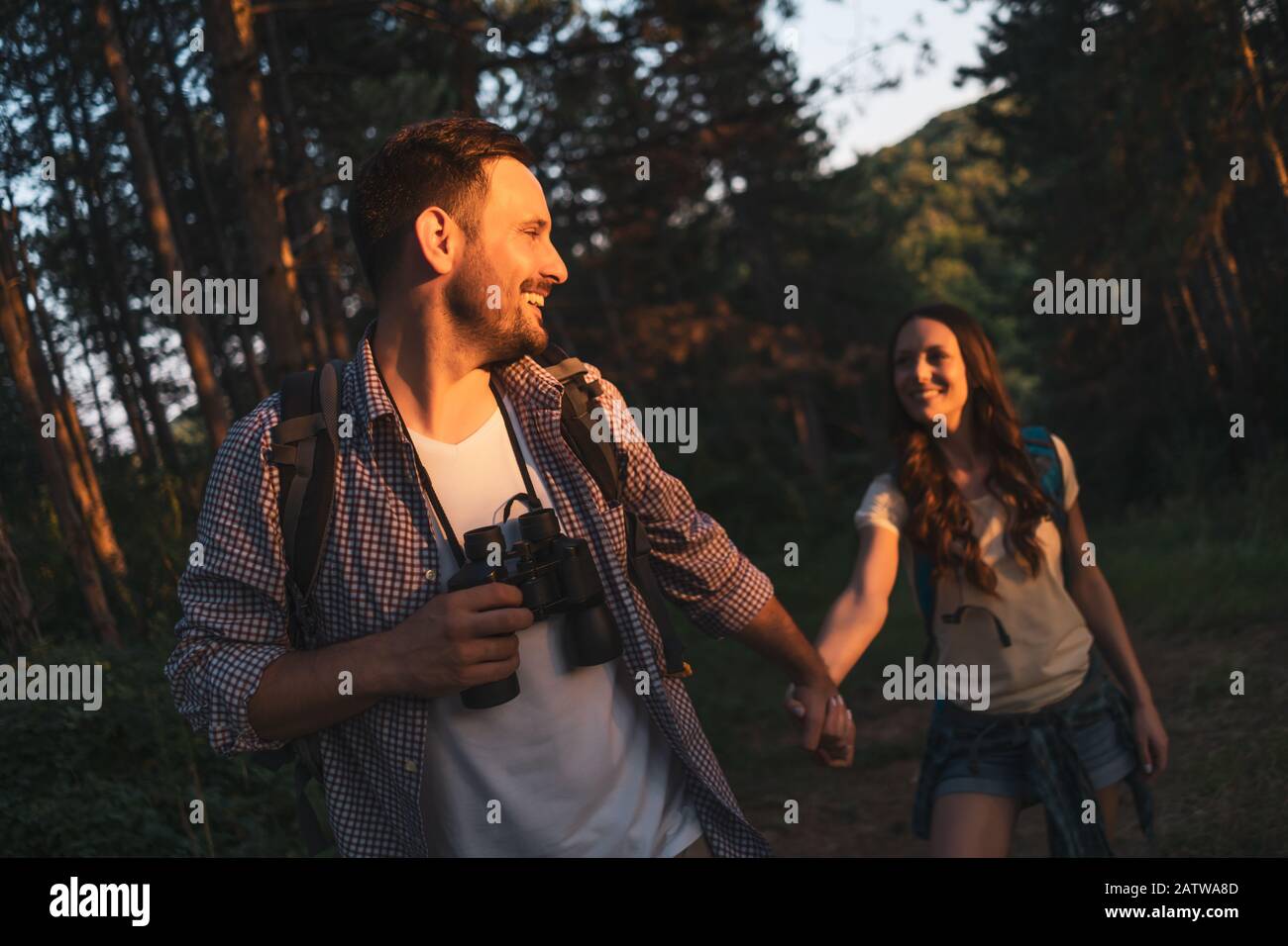 Un couple heureux fait de la randonnée dans la forêt l'après-midi. Banque D'Images
