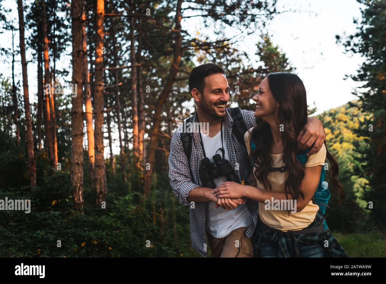 Un couple heureux fait de la randonnée dans la forêt l'après-midi. Banque D'Images
