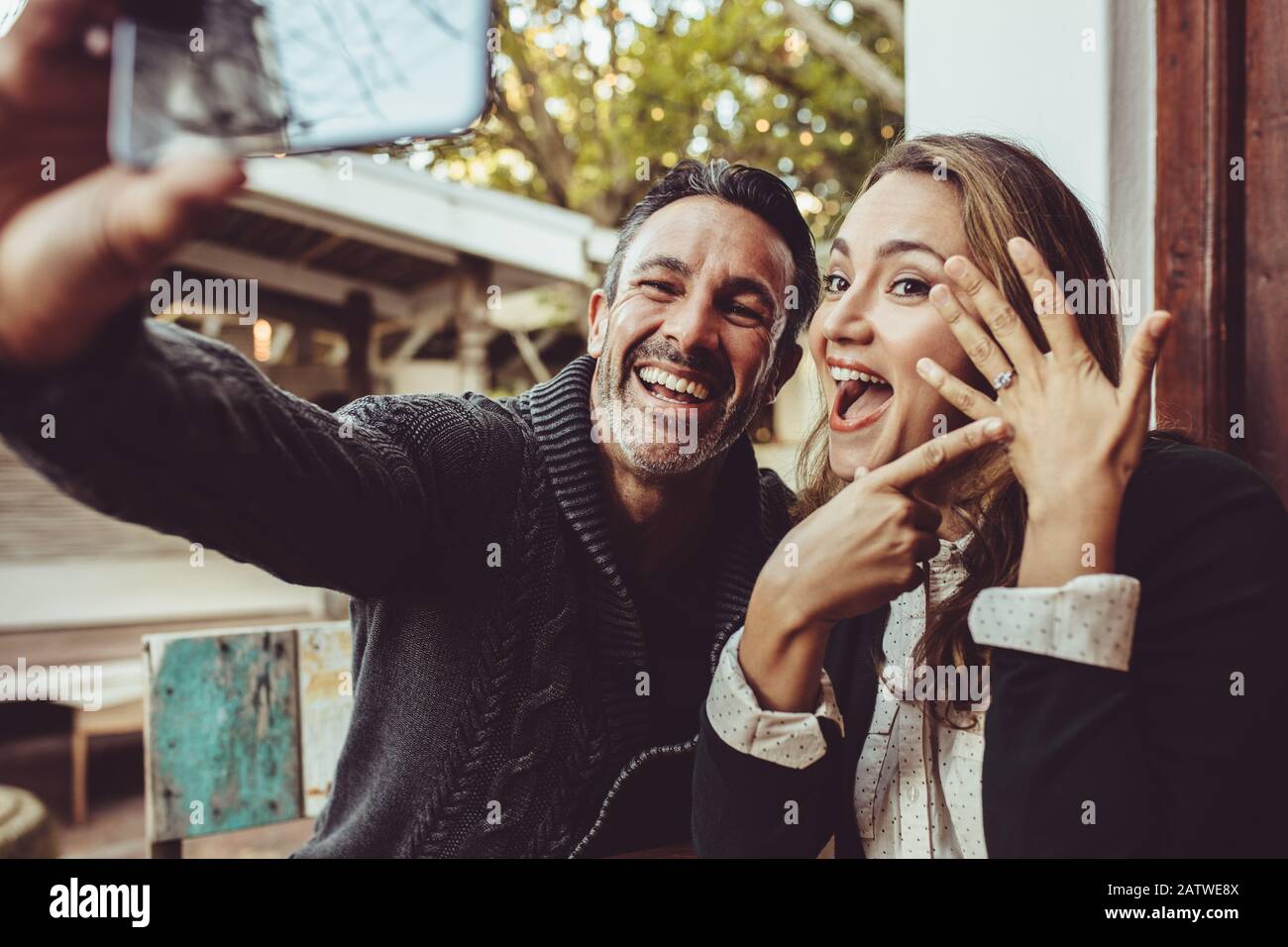 Couple affectueux annonçant leur engagement avec des selfies tout en étant  assis au café. Un couple heureux prenant un selfie et montrant leur anneau  de mariage à Photo Stock - Alamy