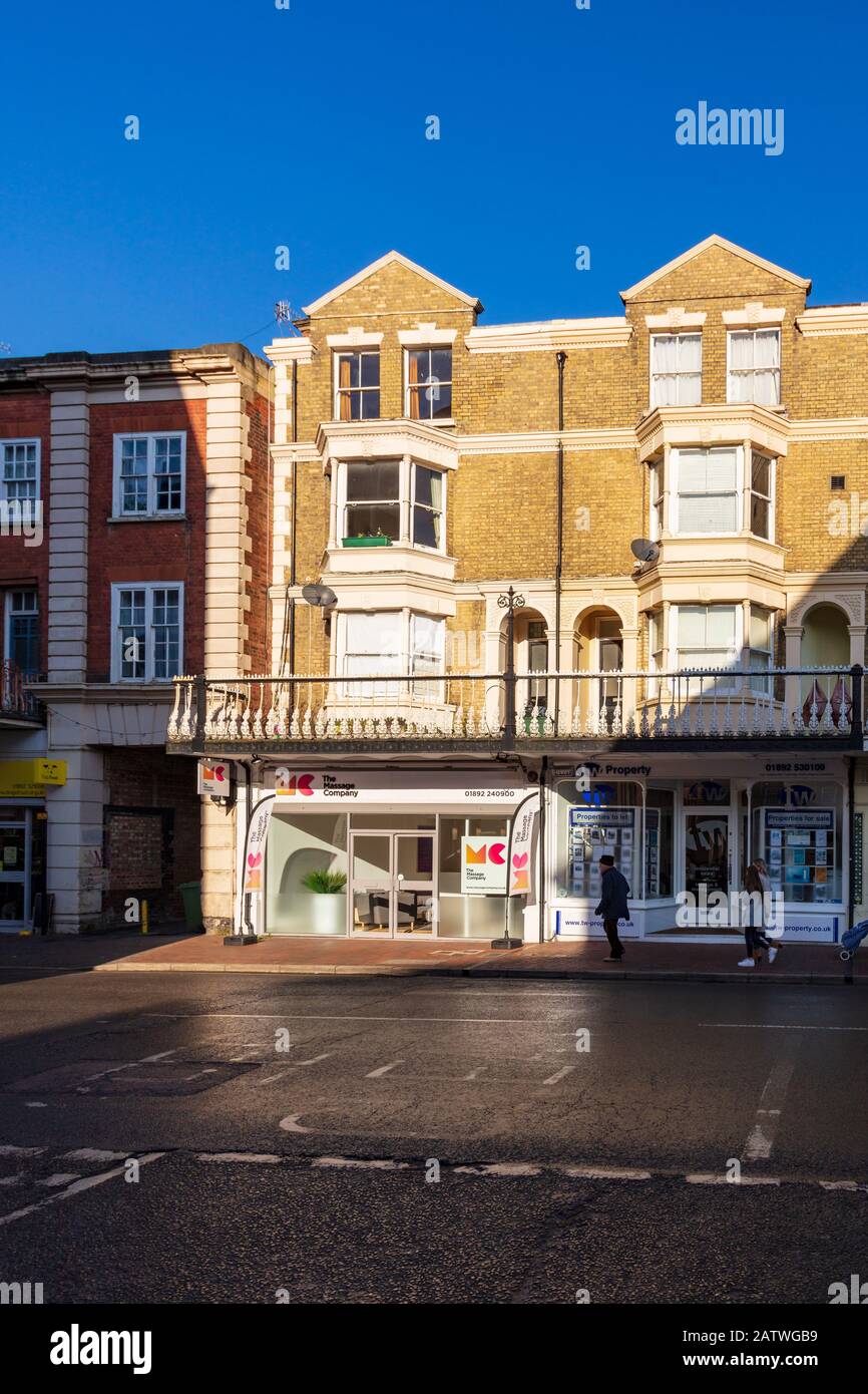 Beau défilé de magasins sur Monson Road, Tunbridge Wells, avec des appartements au-dessus avec un balcon et balustrade décorative en fer Forgé, Kent, Royaume-Uni Banque D'Images