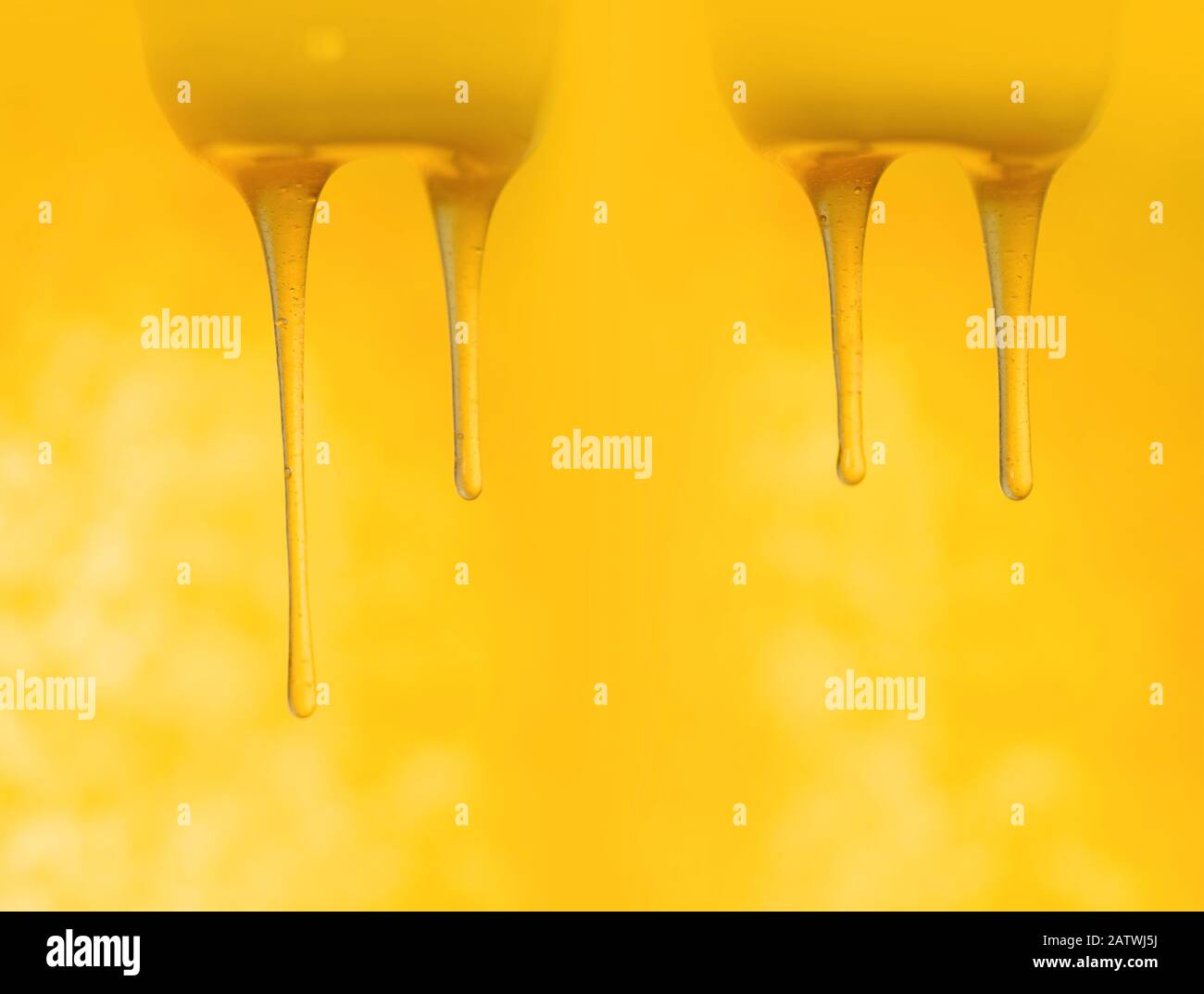 Éclaboussures de miel sucré biologique. Le miel s'écoule de la cuillère à miel en bois Banque D'Images