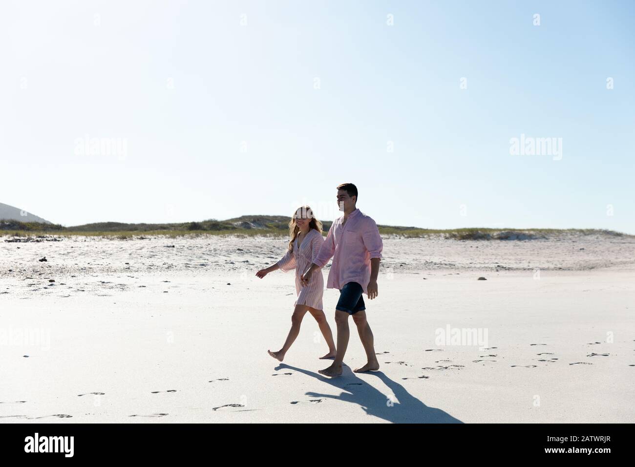 Vue latérale sur les jeunes couples à la plage Banque D'Images