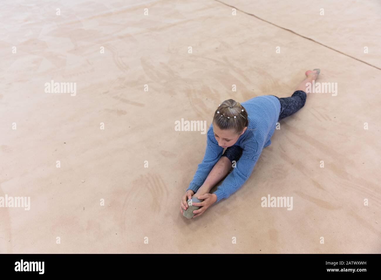 Gymnastique qui s'étend à la salle de gym Banque D'Images
