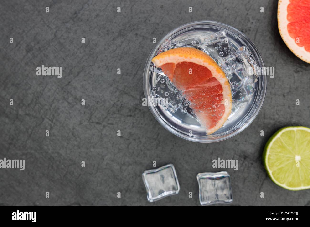 Cocktail de pamplemousse soda de vodka tonique de gin rose en verre avec glace, vue sur le dessus sur fond sombre Banque D'Images