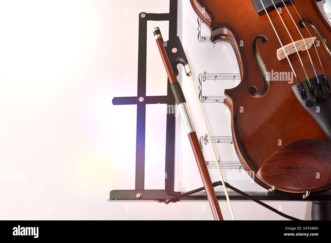 Violon sur le stand de musique et score sur fond blanc isolé. Vue de face. Composition horizontale. Banque D'Images