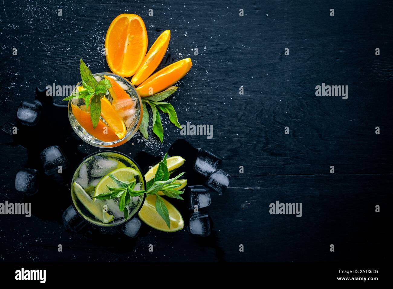 Cocktails rafraîchissants d'agrumes et de menthol avec glace, sur une surface en bois noir. Vue de dessus. Espace libre. Banque D'Images